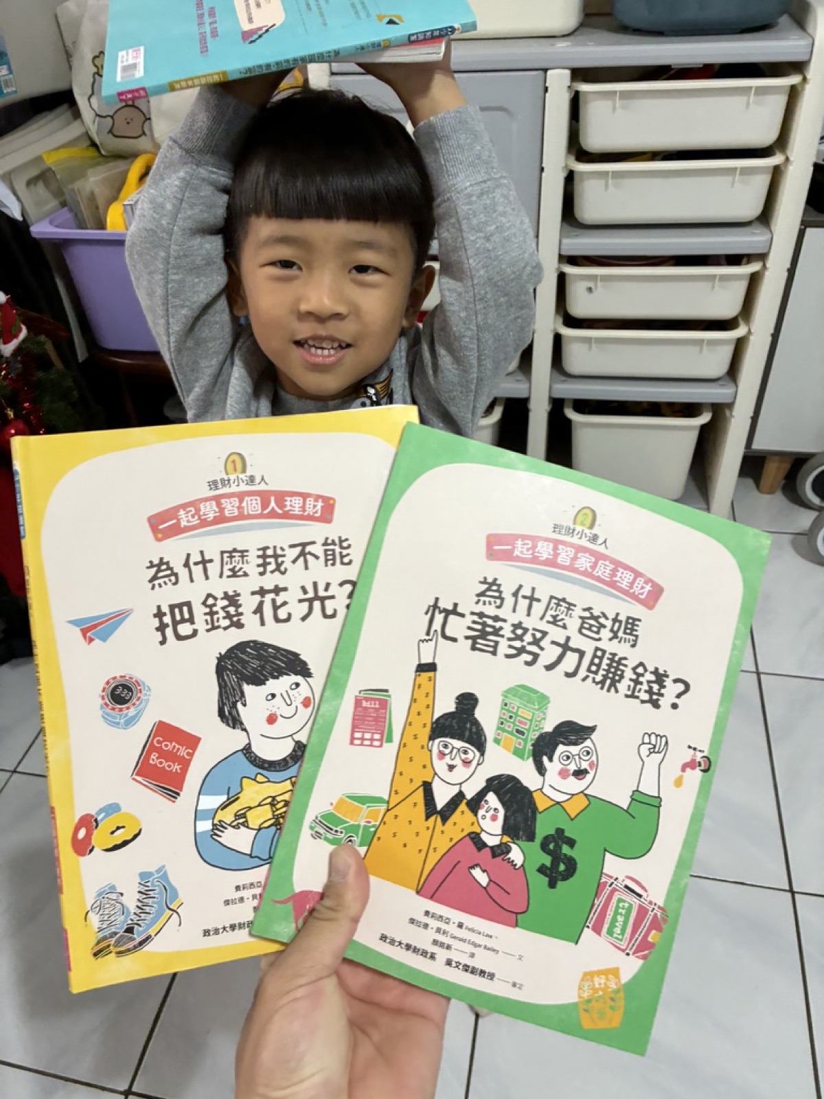 兒子頭頂繪本、手拿理財小達人童書(生活財商教室)