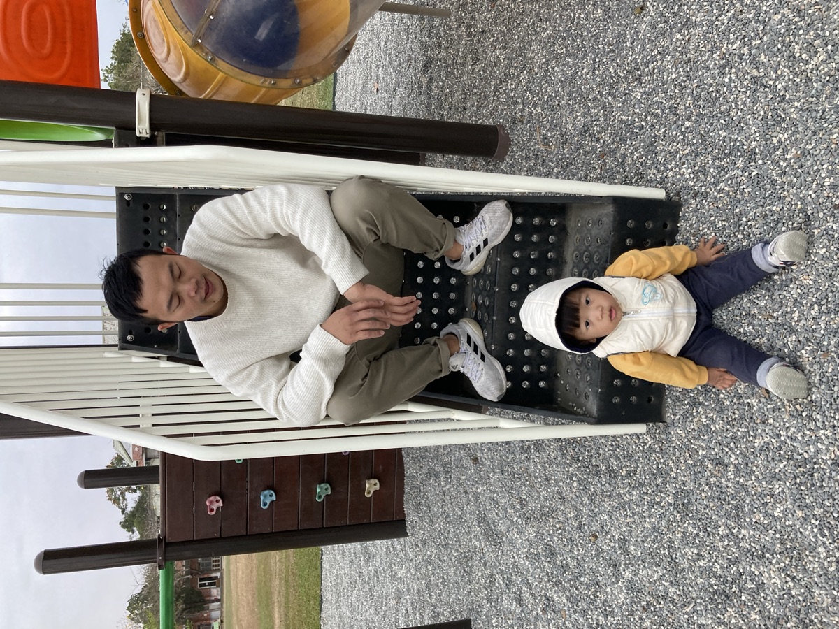 Shawn 在公園陪孩子玩（父親身份側拍）